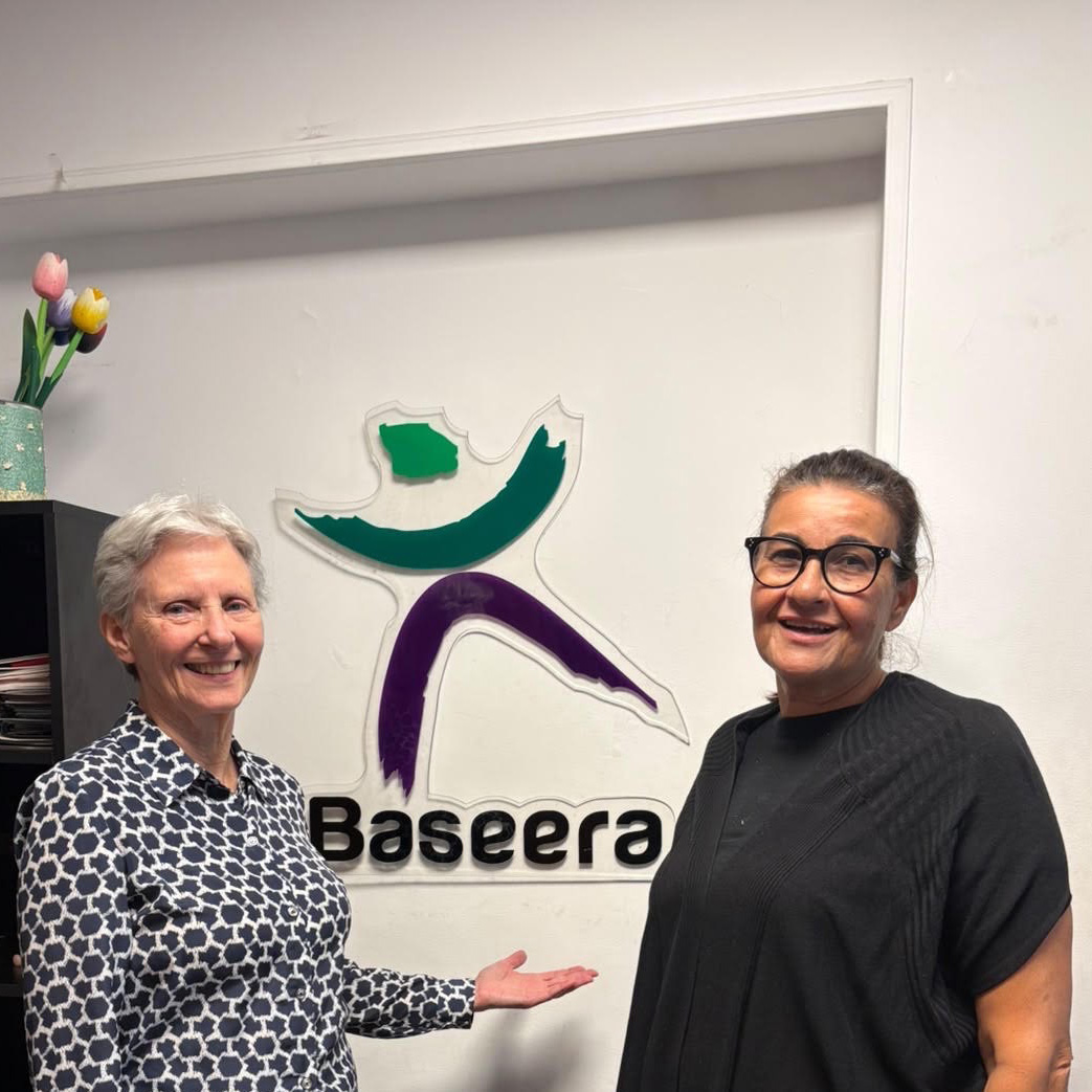 Elly and Doaa standing in front of an office sign for Baseera